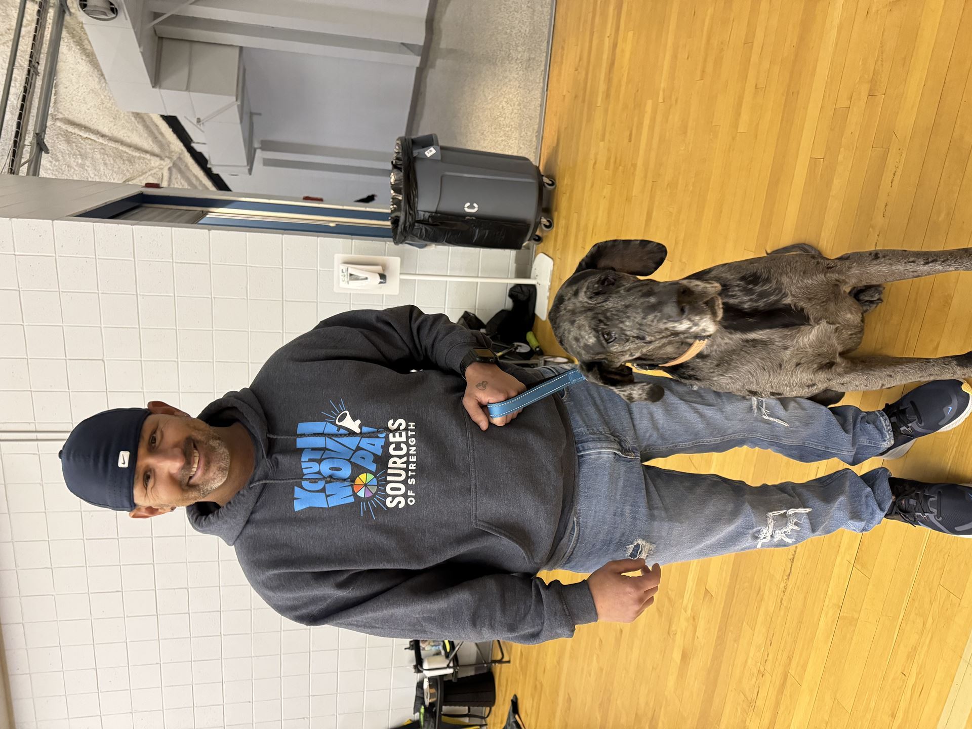 Our Program Director, Kevin, wearing a Youth MOVE PA hoodie and standing with a sweet older dog.